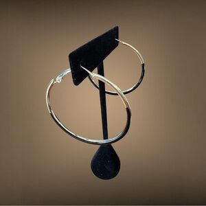 Women’s large gold tone hoops with black enamel on them. NWOT never worn. Cute!
